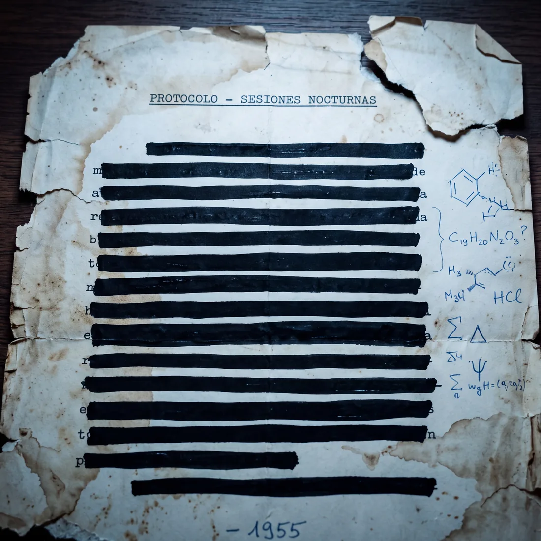 Typewritten fragment on torn, stained paper, with black-ink strike-outs, references to night sessions and a handwritten formula.